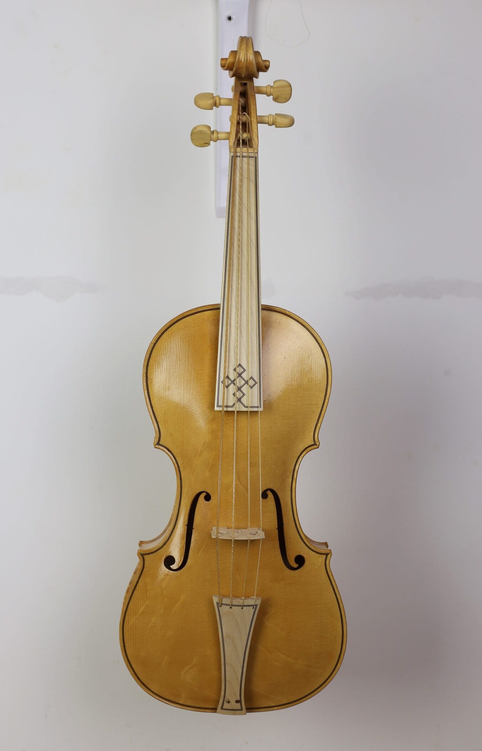 Vooraanzicht van een viool met snaren, brug, f-gaten en versierde toets zichtbaar