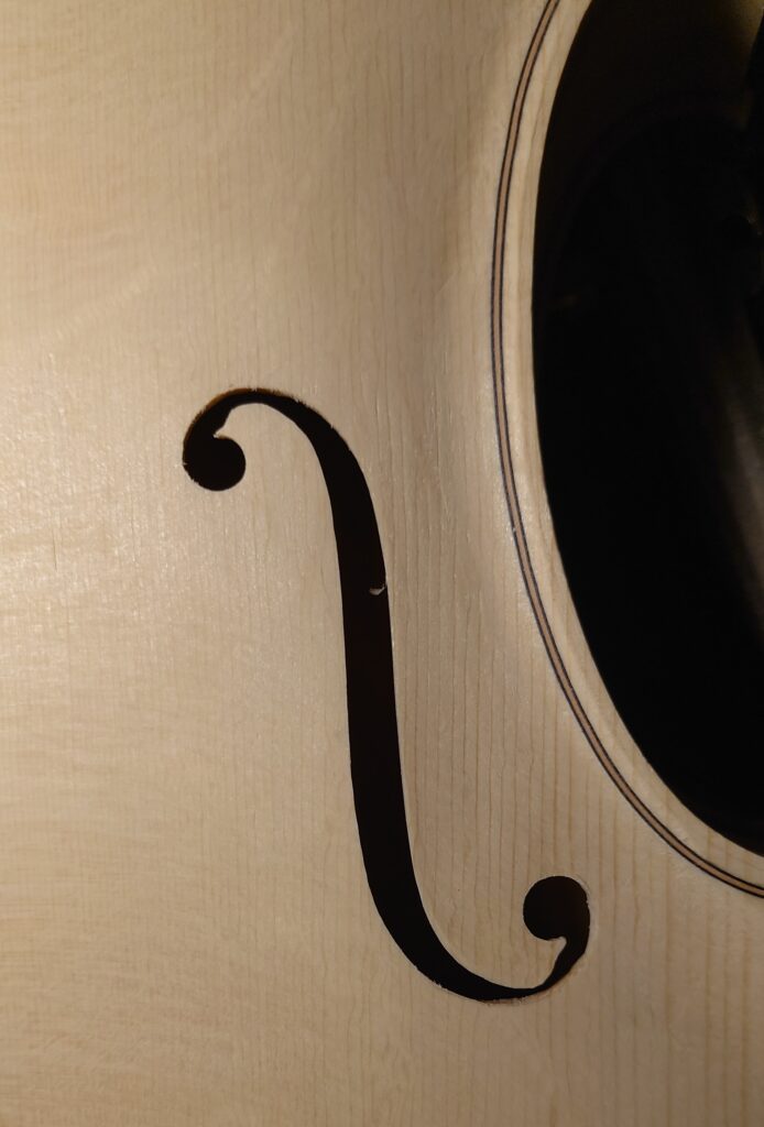 F-gat van een vioolblad naast de rand van de klankkast, detail van traditioneel vioolbouwvakmanschap